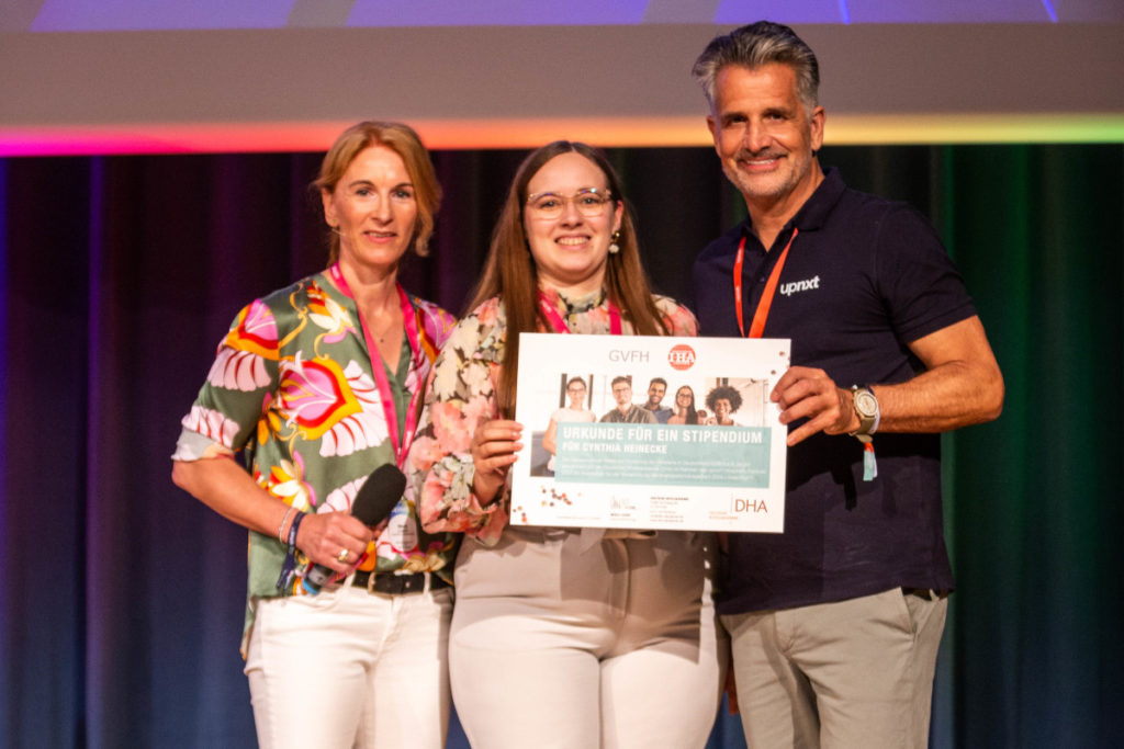Merle Losem, Geschäftsführerin DHA (li.), und Otto Lindner, Vorsitzender GVFH und IHA (re.), gratulieren Cynthia Heinecke zum Nachhaltigkeitsmanagement-Stipendium. © seehundmedia