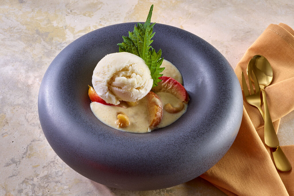 Lauwarmes Bratapfelkompott unter Zimt-Kürbiskern-Crumbles und cremigen Vanille Eiscreme, Foto beigestellt