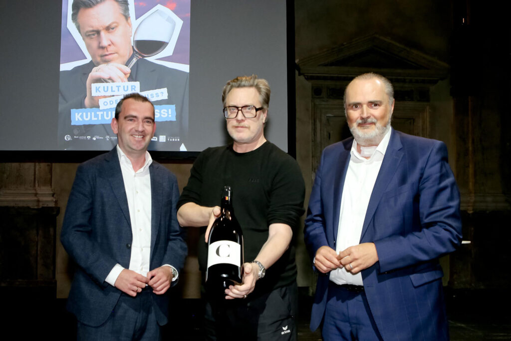 Weintourismus Burgenland-Obmann Herbert Oschep (1.v.l.) und Landeshauptmann Hans Peter Doskozil (3.v.l.) überreichen Nicholas Ofczarek (2.v.l.) eine Flasche Centum-Jahrhundertwein. @ Burgenland Tourismus/Andreas Lepsi